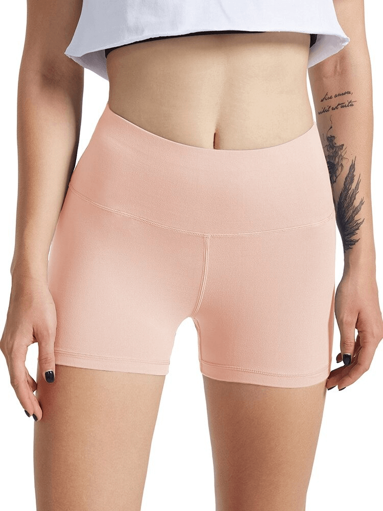 Woman wearing pink sporty elastic short shorts with high waist, ideal for training sessions, featuring polyester and spandex blend.